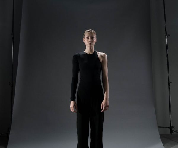 Person standing in a balanced yoga pose against violet glow